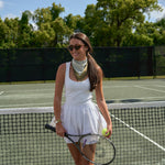 Woman wearing the Sevy Lake Shore UPF 50+ sun bandana in Moss for tennis
